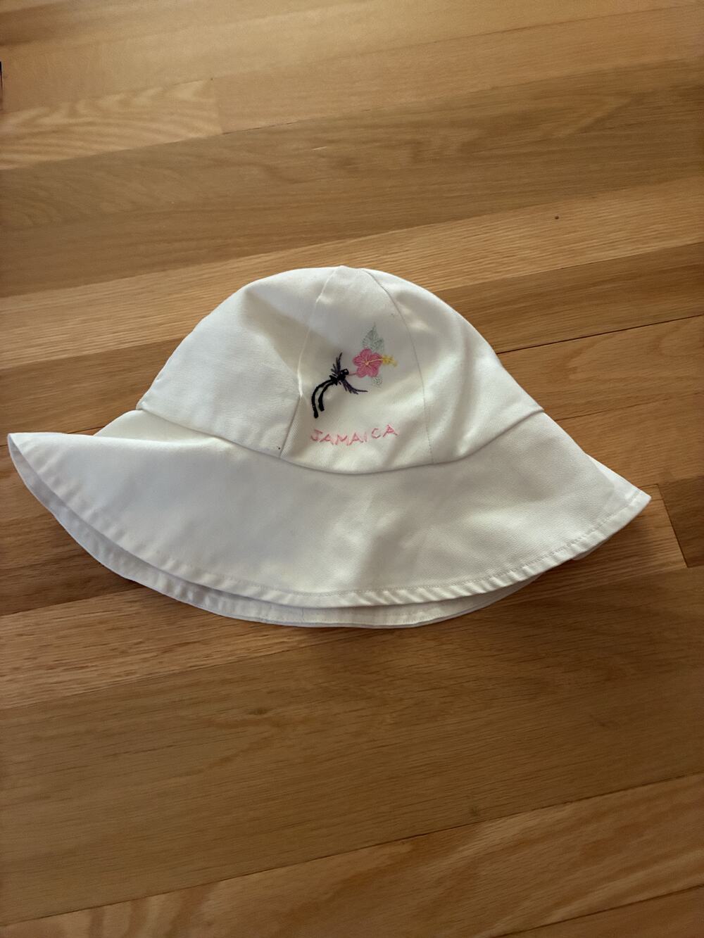 Anancy white wide brim bucket hat with embroidered hibiscus and Jamaica letterin